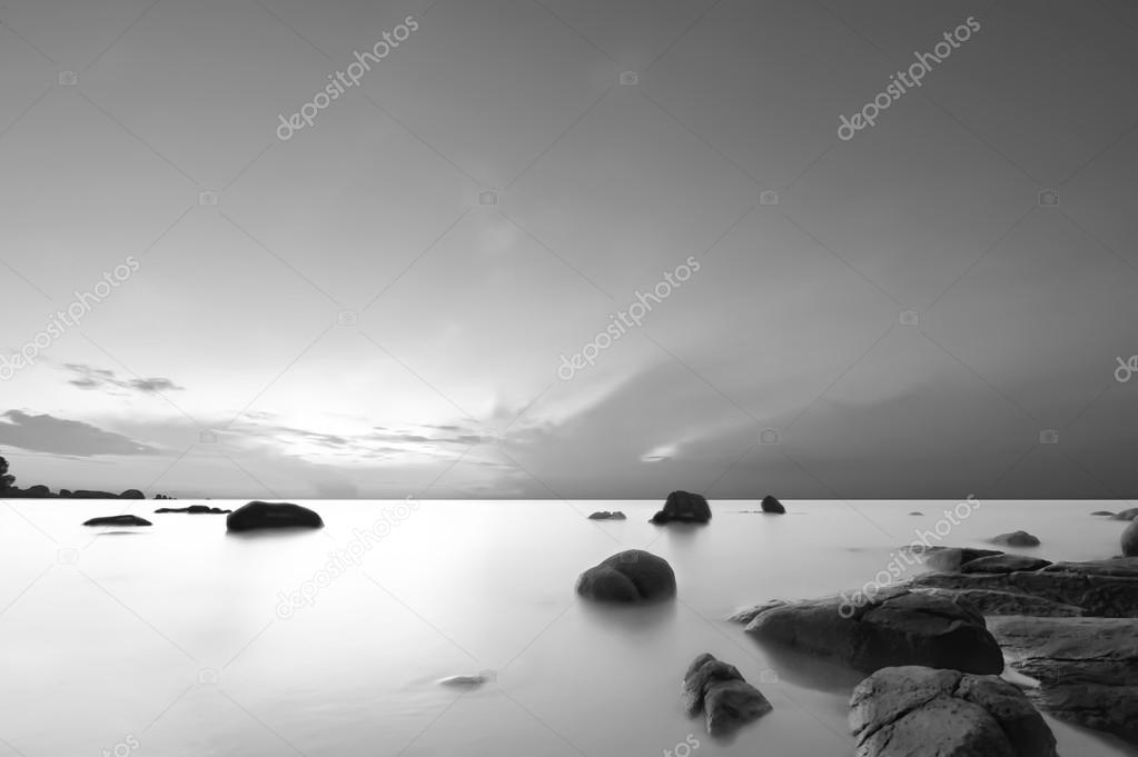 Sunrise at rocky tropical beach.