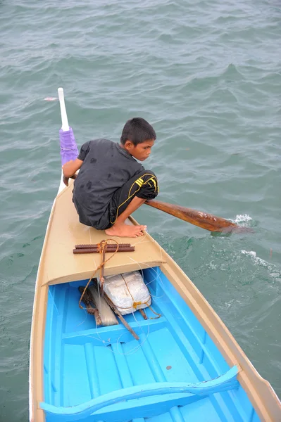 SEMPORNA, MALAYSIA- 5 DE MARZO DE 2015: Niño bajau no identificado acolchado en un barco tradicional en Semporna, Malasia. Bajau a veces han sido llamados los "gitanos del mar" o "nómadas del mar" . —  Fotos de Stock