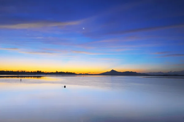 Zonsopgang op tropisch strand met berg als achtergrond. — Stockfoto