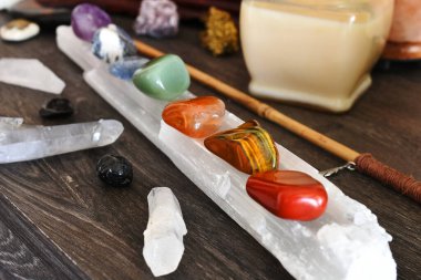 A close up image of seven chakra healing crystals charging on a selenite wand.  clipart