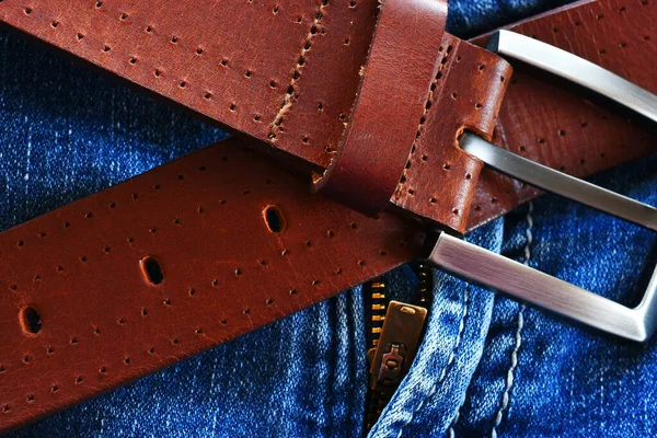 古い赤茶色の革のベルトと色あせた青のジーンズのペアのクローズアップイメージ — ストック写真