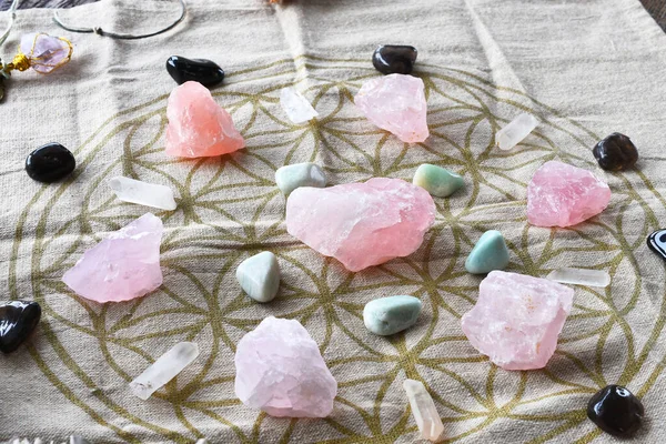 A close up image of a self love and self healing crystal grid using sacred geometry and rose quartz crystals.
