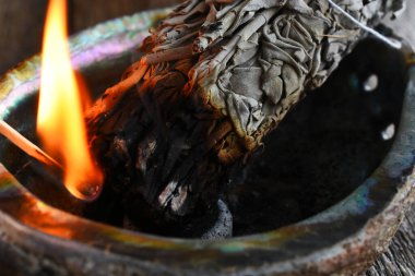 Yakın plan bir resim. Ahşap kibritle yakılan beyaz adaçayı lekesi..  