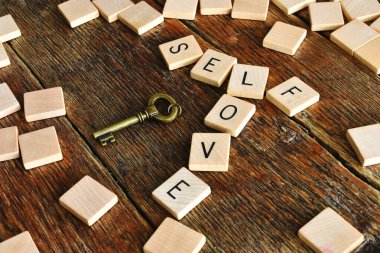 Ahşap alfabe bloklarının yakın plan görüntüsü kendini sevmenin ilham verici mesajını ortaya koyuyor..