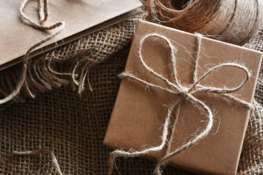 Koyu ahşap bir masanın üstüne sarılı eski tarz bir paket.. 