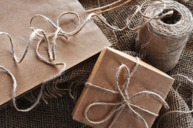 Koyu ahşap bir masanın üstüne sarılı eski tarz bir paket.. 