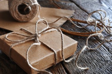 Koyu ahşap bir masanın üstüne sarılı eski tarz bir paket.. 