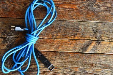 Tahta masadaki eski mavi bir elektrik kablosunun üst görüntüsü.. 
