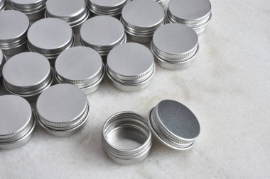 Beyaz mermer bir masanın üstündeki birkaç gümüş metal numune kutusunun yakın plan görüntüsü.. 