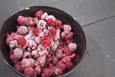 Koyu ahşap arka plan üzerinde dondurulmuş ahududu