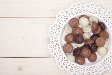 Beyaz ahşap zemin üzerinde beyaz tabakta geleneksel Hollandalı çikolata şeker pepernoot