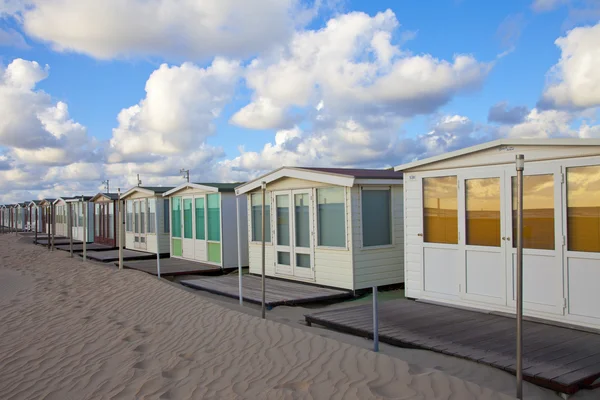 Várias casas de praia em uma fileira na praia na Holanda — Fotografia de Stock