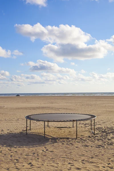 Cama elástica vacía en la playa con cielo azul — Foto de Stock