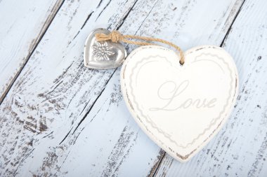 Beyaz kalp hafif mavi ahşap arka plan üzerinde metin aşk ile
