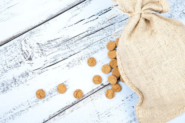 Hollandalı şeker pepernoot jüt çanta beyaz mavi ahşap zemin üzerinde