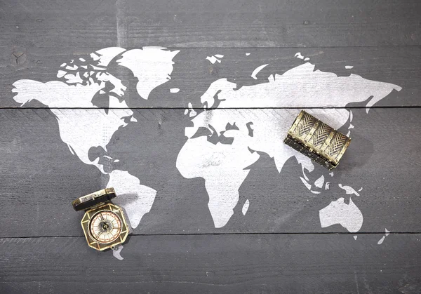 Mapa del mundo con brújula y tesoro sobre fondo negro oscuro de madera —  Fotos de Stock