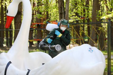 MINSK, BELARUS - 1 Ekim 2020: İşçiler Coronavirüs 'e karşı çocuk parkındaki eğlenceleri dezenfekte ediyorlar