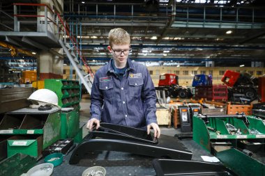 MINSK, BELARUS - 1 EKİM, 2020: Genç işçiler fabrikada araba montajı yapıyorlar