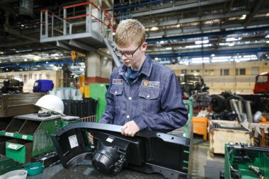 MINSK, BELARUS - 1 EKİM, 2020: Genç işçiler fabrikada araba montajı yapıyorlar