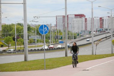 MINSK, BELARUS - 1 EKİM, 2020: Bir adam şehir merkezinde bisiklet yolunda bisiklet sürüyor