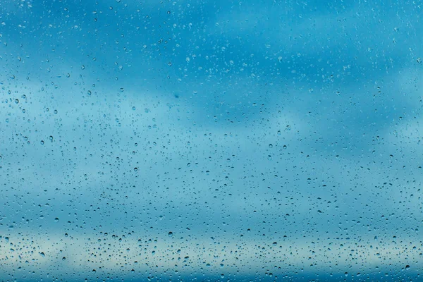 Raindrops on the transparent window pane. Background of raindrops.