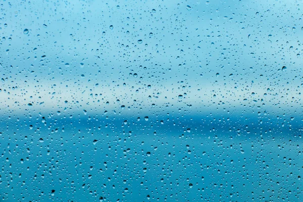 Raindrops on the transparent window pane. Background of raindrops.