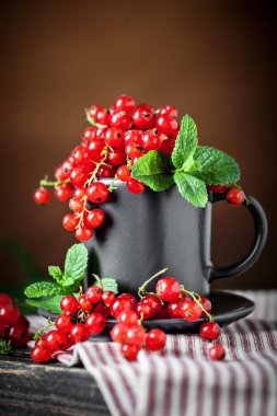 Koyu kırsal ahşap masada taze kırmızı frenk üzümü. Kopya alanı olan bir arkaplan. Seçici odak.