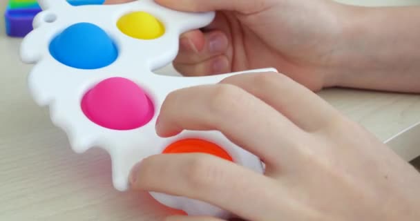 Child is playing trendy popular board game anti-stress toy pop it. Multi-colored popular silicone anti-stress toy pop it. — Stock Video