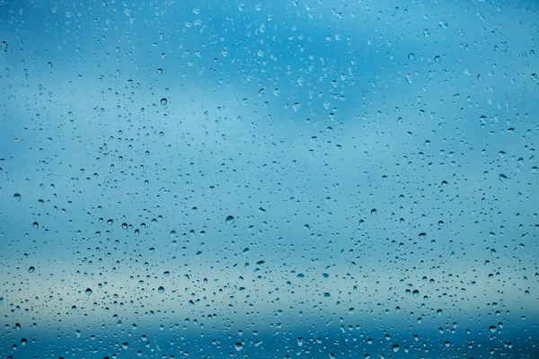 Raindrops on the transparent window pane. Background of raindrops.