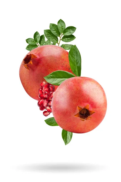 Ett moget granatäpple med frön och blad som flyger i luften. Isolerat objekt på en vit bakgrund. Bakgrund med granatäpplen frukt. — Stockfoto