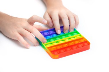 Silikon oyuncak bir gencin ellerinde anti-stres. Stres önleyici renkli oyuncak. Yeni moda. Renkli stres önleyici oyuncaklar. Kıpırdayın. Kıpırdayın..