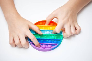 Silikon oyuncak bir gencin ellerinde anti-stres. Stres önleyici renkli oyuncak. Yeni moda. Renkli stres önleyici oyuncaklar. Kıpırdayın. Kıpırdayın..