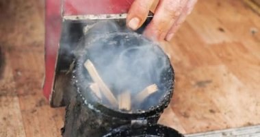 Arı yetiştiricisi, arıları pasifleştirmek için kovan dumanı kullanıyor. Profesyonel arıcılık. Çiftçilik süreci. Organikler.