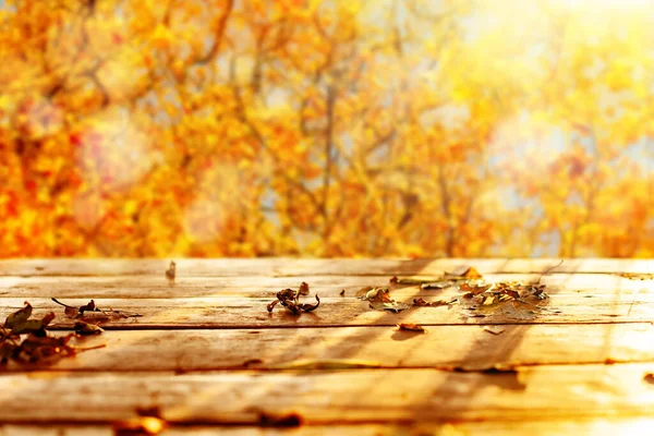 Mesa de madera y fondo borroso de otoño. Concepto otoñal con fondo de hojas rojo-amarillas. maqueta de otoño. Imágenes de stock libres de derechos