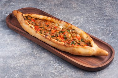 Tahta üzerinde et ve sebzelerle nefis bir pide. Türk mutfağı
