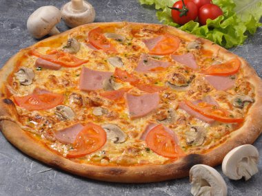 Gri arka planda jambonlu ve mantarlı lezzetli pizza.