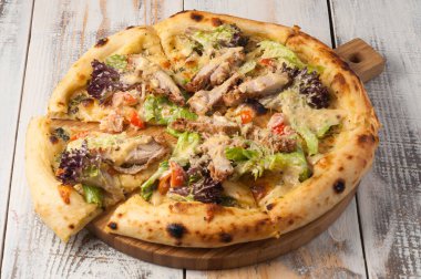 Tavuk, marul, vişneli domates ve parmesanlı lezzetli pizza.