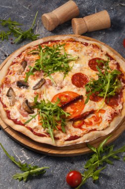 Farklı dolgulu lezzetli pizza: salam, domates, mantar, pastırma, güneşte kurutulmuş domates. Dikey çerçeve