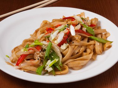 Beyaz tabakta sebzeli erişte.