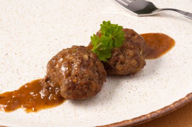 Bir tabak yeşillikte iki lezzetli köfte. Kapat.