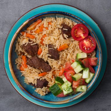 Lezzetli geleneksel doğu yemeği: sığır eti ve sebze salatalı pilav. Üst görünüm