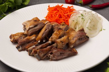 Kemikte lezzetli kuzu şişleri, soğan ve havuçla birlikte.