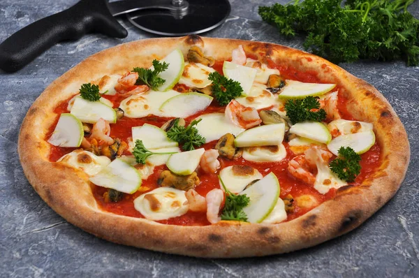 tasty pizza with shrimp, mussels, zucchini and mozzarella cheese