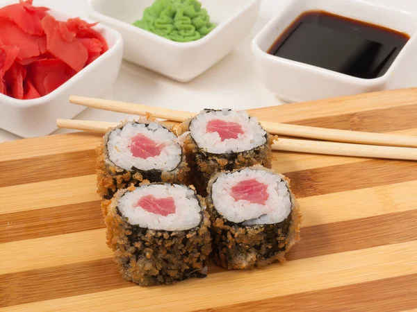 hot sushi rolls with tuna on a wooden Board