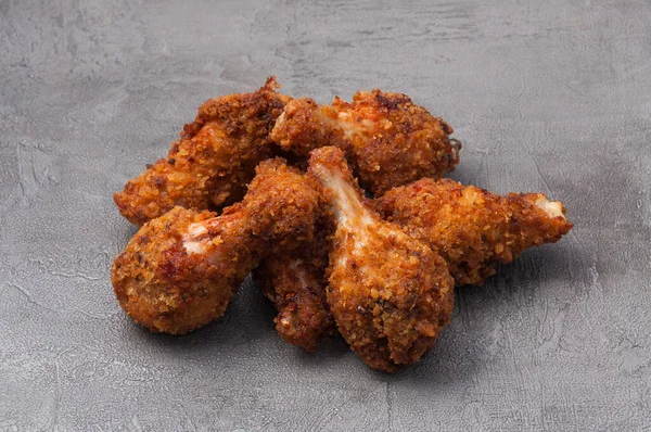tasty fried crispy breaded chicken wings on a gray background