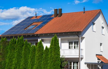 Generic modern house (modified by image editing) with photovoltaic solar cells on the roof for alternative energy production clipart