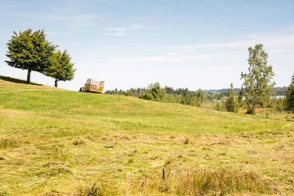 Traktor med släp på en betesmark — Stockfoto