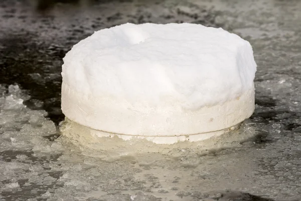 Floating ice preventer in a frozen pond — Stock Photo, Image