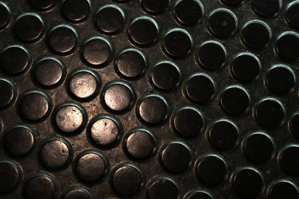 Black  rubber floor with dots, non-slip matting in industrial setting