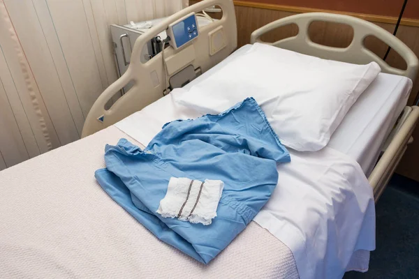 A Blue medical operation shirt and white operation underware lying on a hospital bed